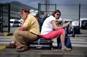 British passengers, stranded by flight cancellations, sit on a suitcase as they wait to board the "Pride of Bilbao" ferry in the Spanish Basque port of Santurce.